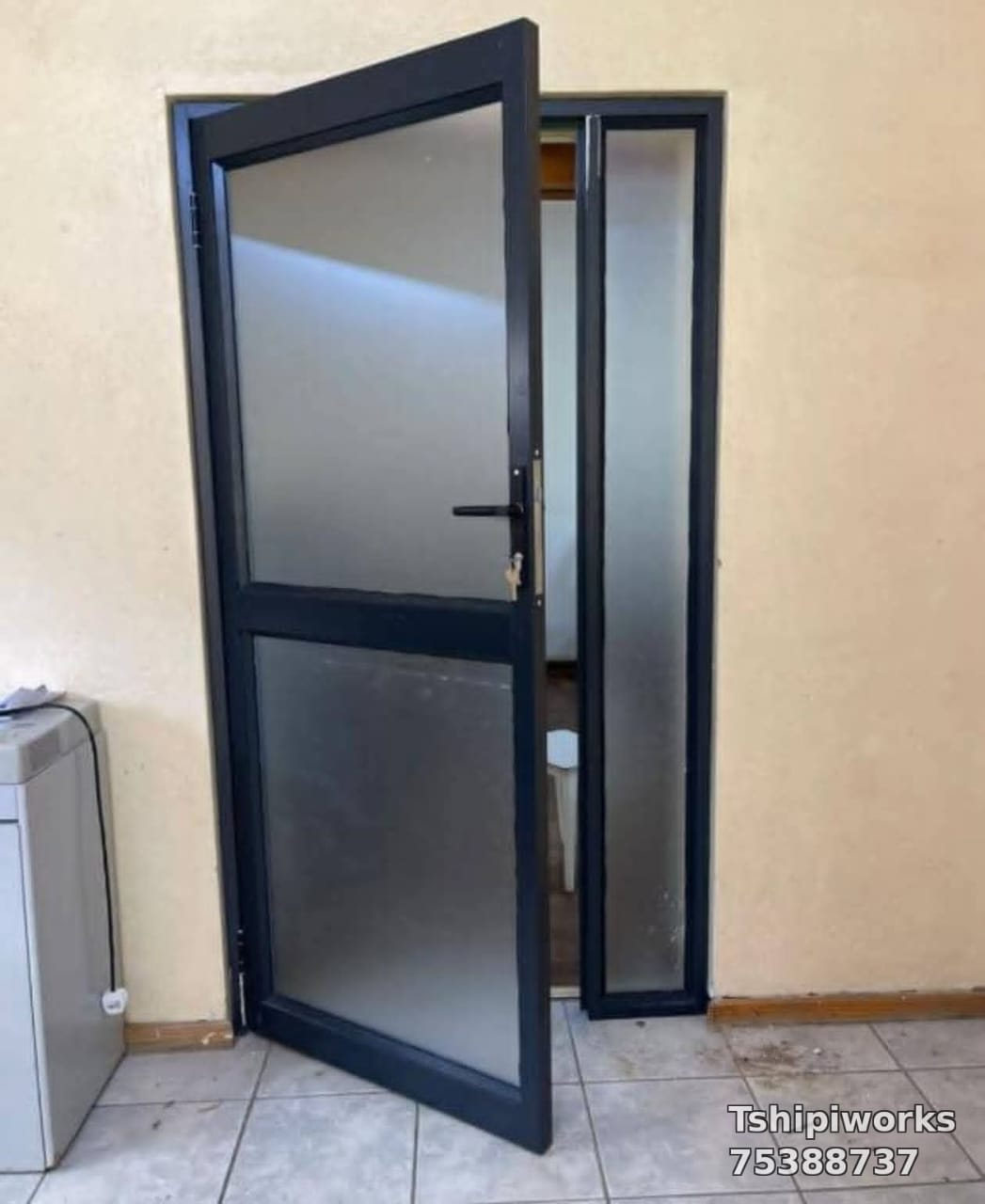 Charcoal aluminium door with frosted glass panels and matching sidelight — Tshipiworks