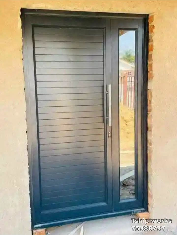 Dark horizontal-slat aluminium panel door with a narrow glazed sidelight — Tshipiworks Botswana