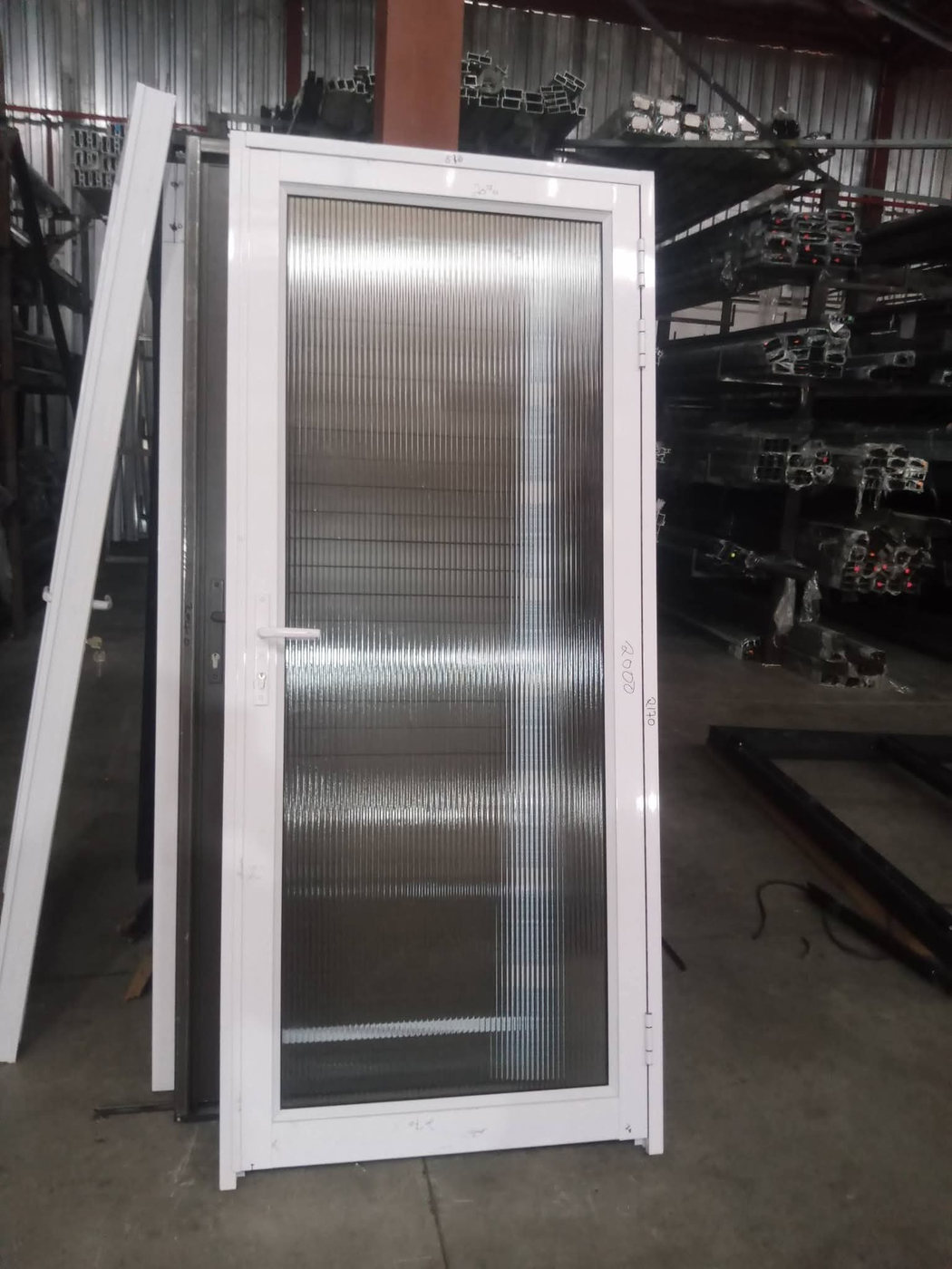 White aluminium workshop door with translucent fluted glass, fabricated by Tshipiworks