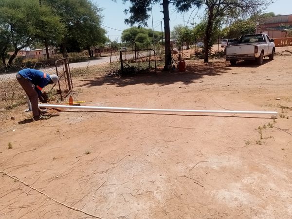 Tshipiworks fitter working on the base of a steel flag pole on site in Tlokweng before it is raised