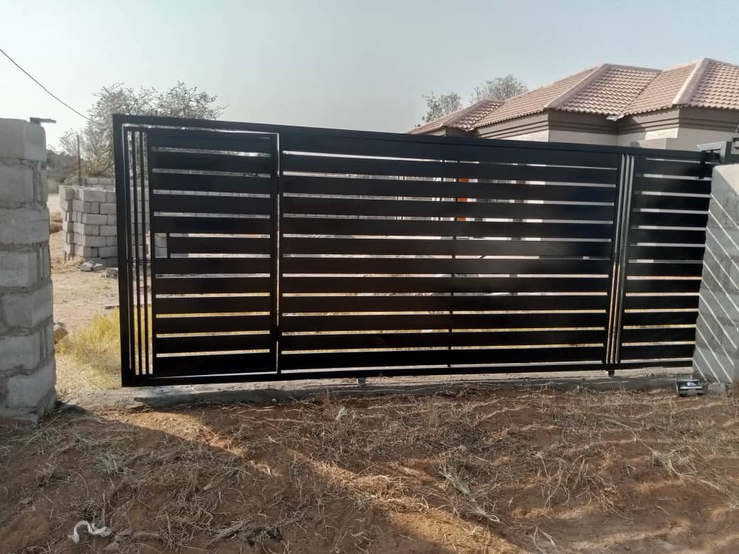 Straight-on black horizontal slat sliding driveway gate — Tshipiworks