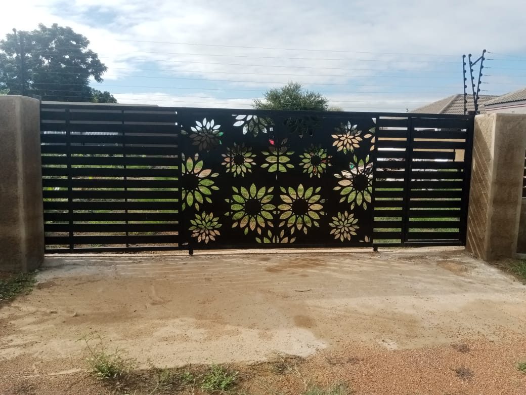 Black fence panel combining sunflower laser-cut motifs with horizontal slats — Tshipiworks