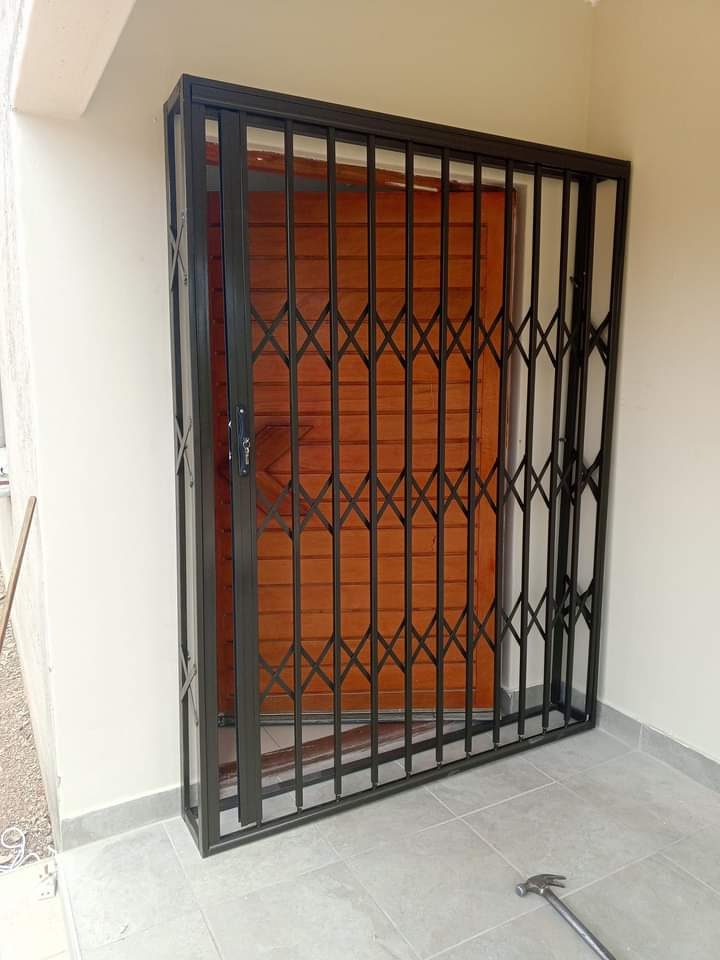 Charcoal steel expandable trellidor over wooden front door — Tshipiworks Botswana