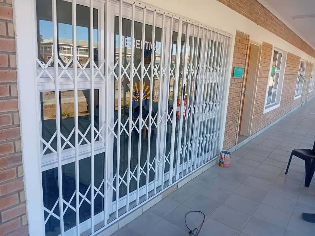 White steel retractable trellidor spanning commercial reception entrance — Tshipiworks