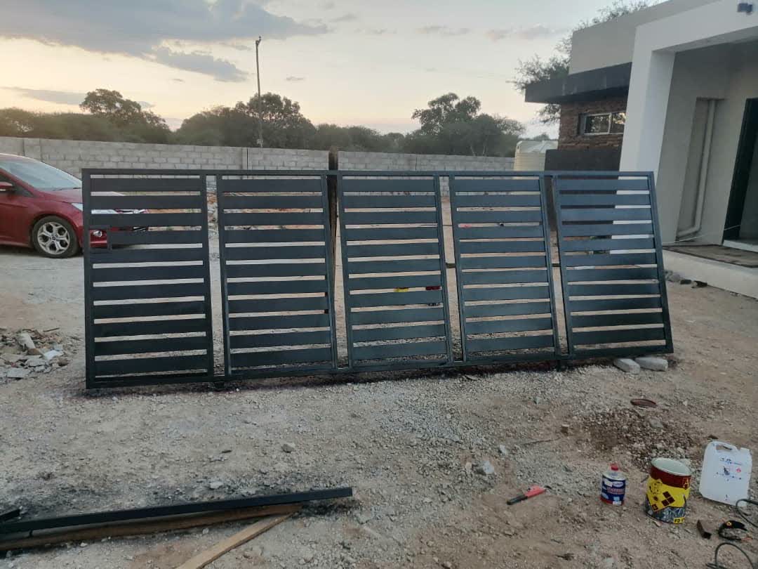 Black horizontal slat sliding gate on a new-build driveway — Tshipiworks