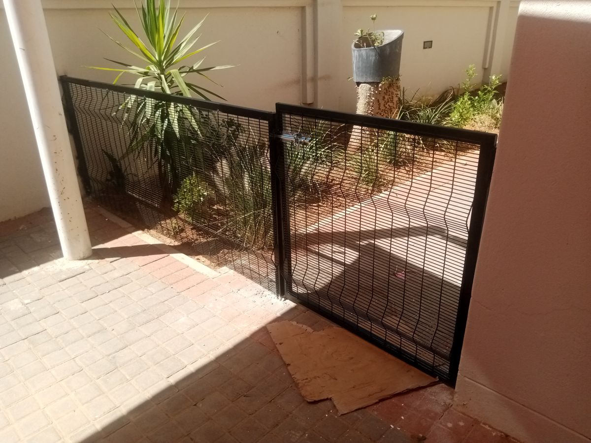 Black welded mesh dog partition with gate at Phakalane Golf Estate, Botswana — Tshipiworks